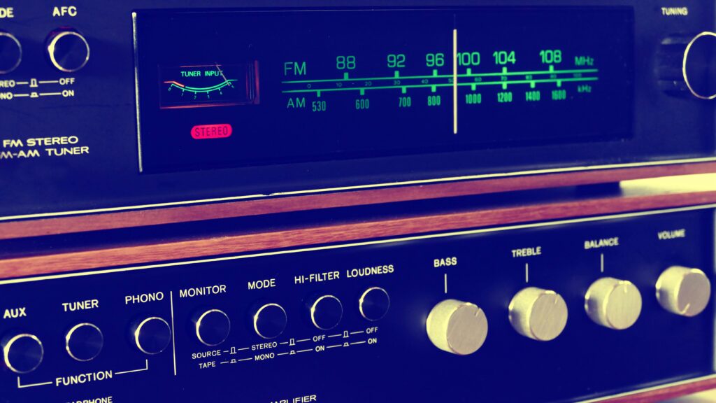 A retro FM-AM stereo tuner with knobs and wooden accents, embodying vintage audio equipment.